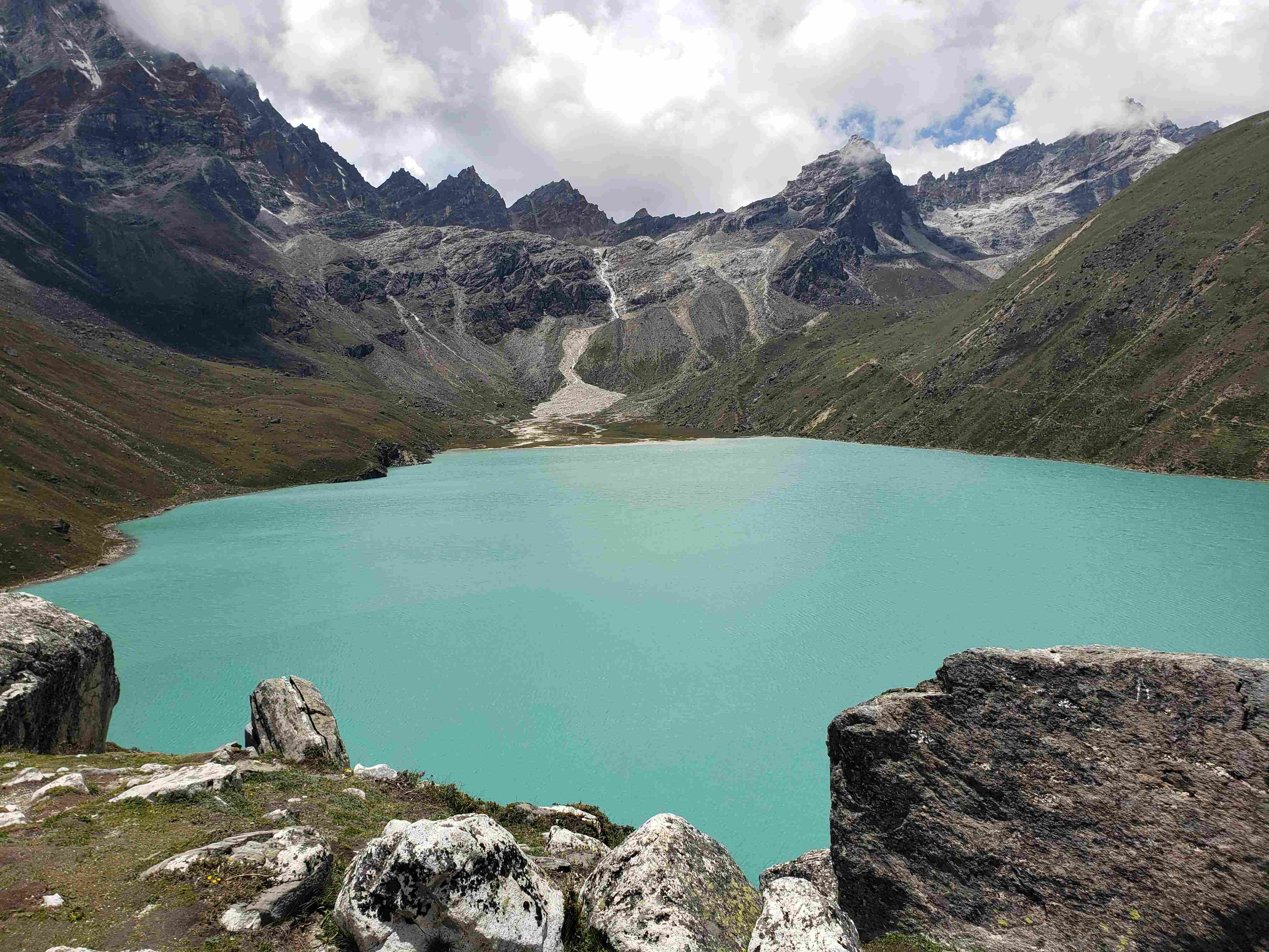 Vibrant turquoise waters of Gokyo Lakes surrounded by rocky terrain.