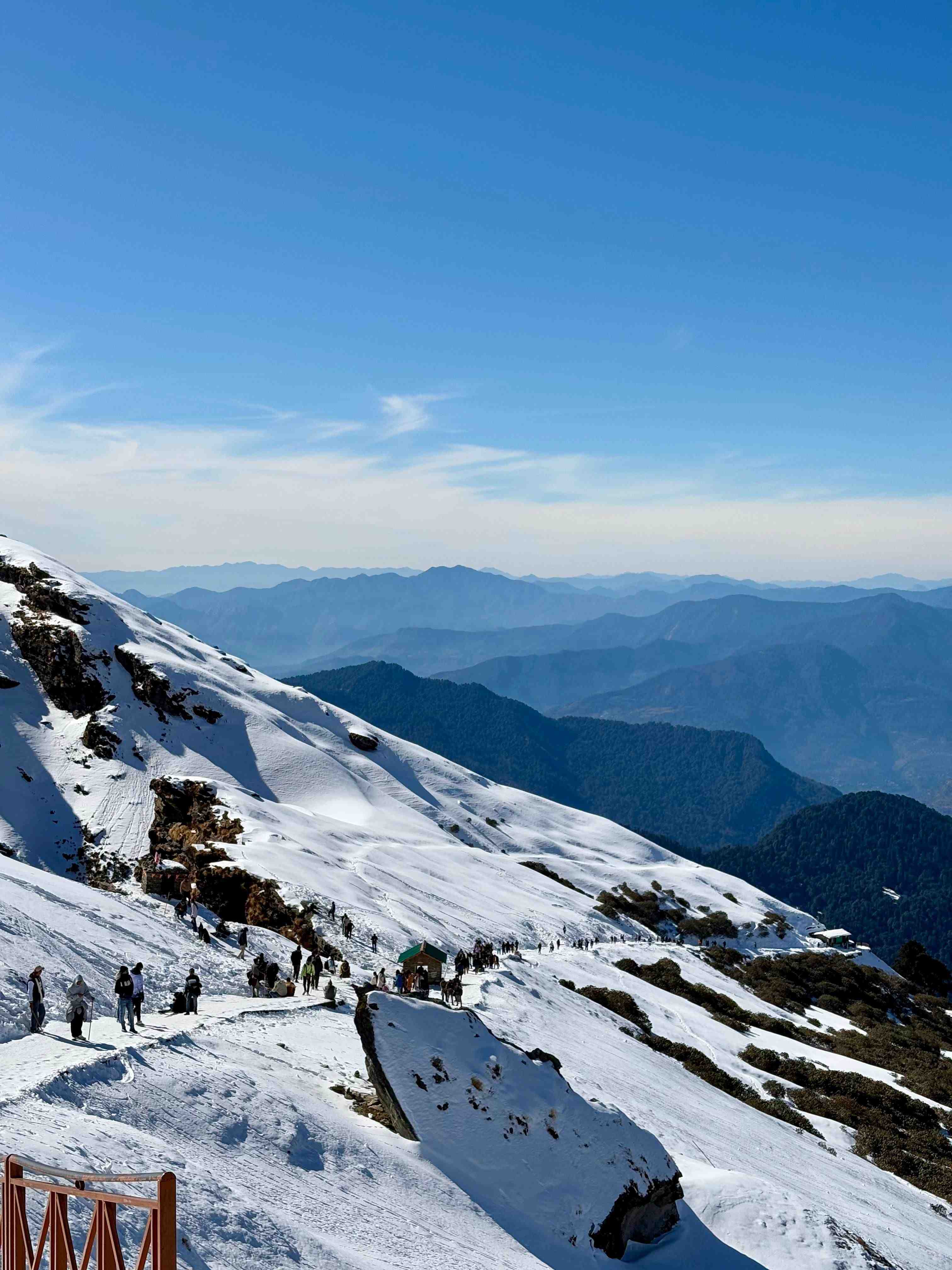 Snow-covered trail near Kedarkantha Summit with mountain views in winter
