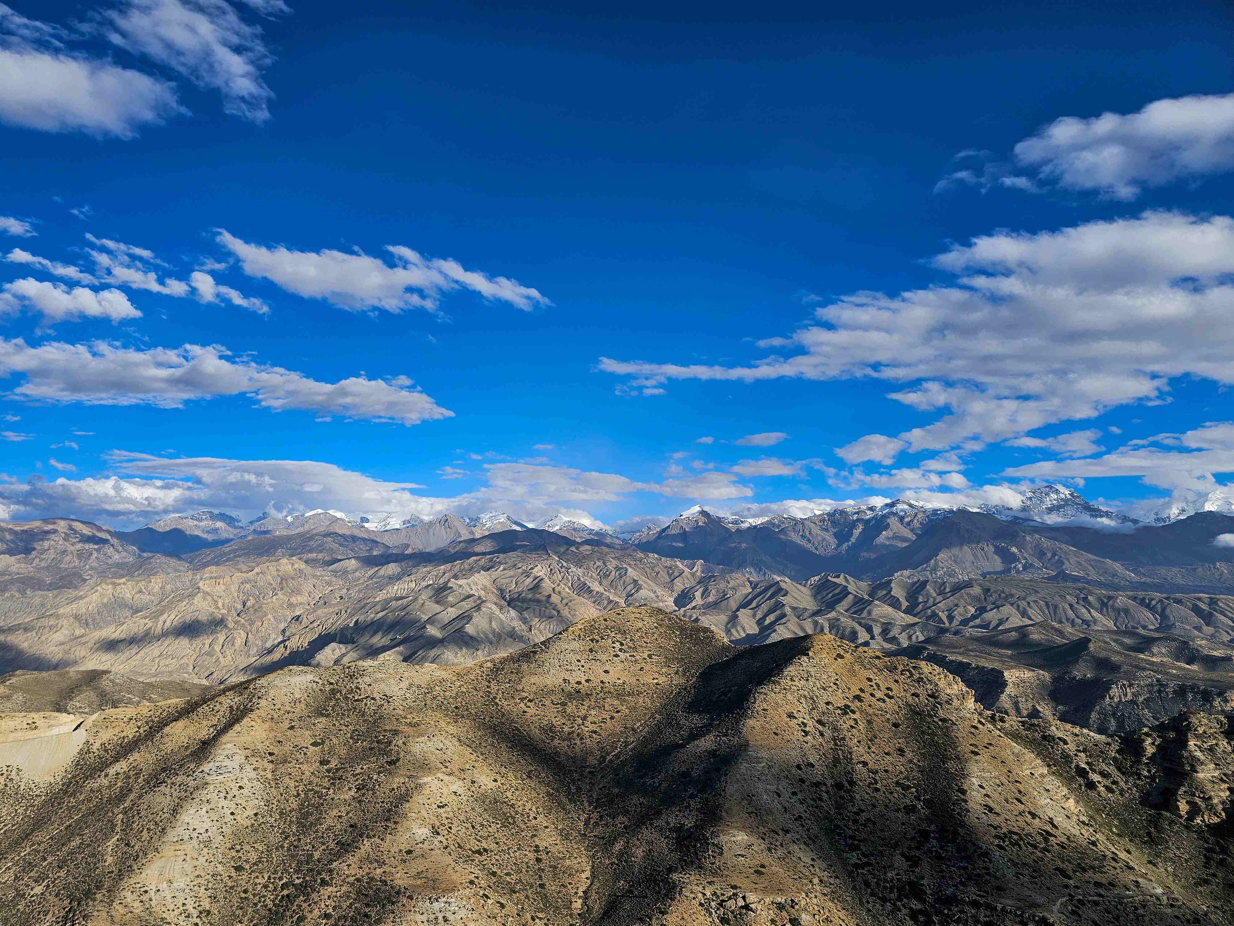 Panoramic view of Upper Mustang Himalayas with barren mountains and snow-capped peaks in Nepal